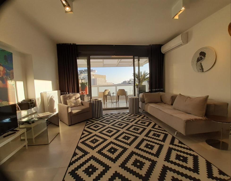 ein Wohnzimmer mit einem Sofa und einem TV in der Unterkunft Art Suite 7 in Thessaloniki