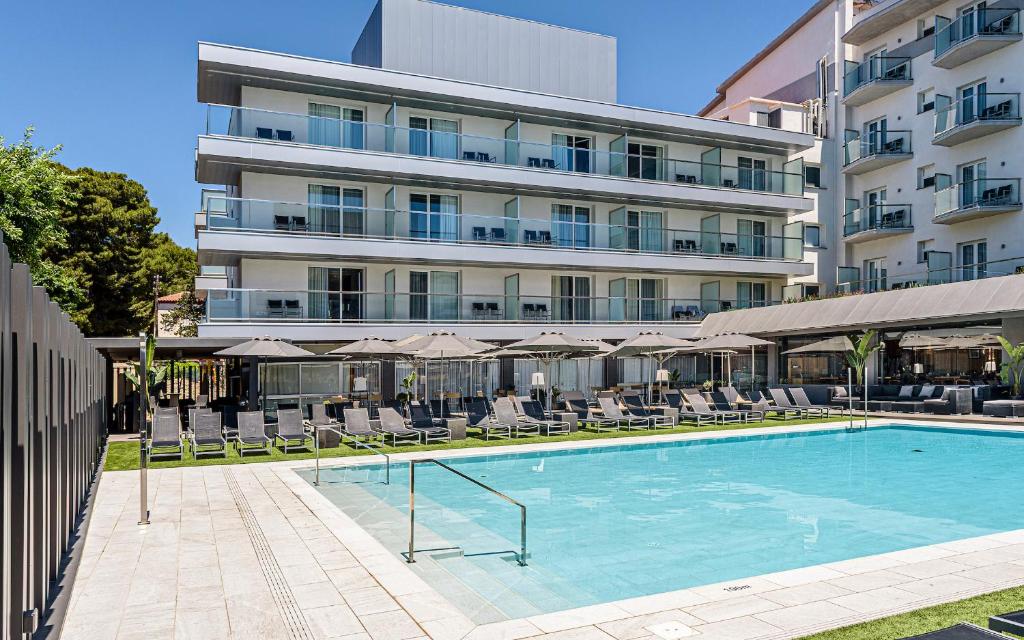 un hotel con piscina frente a un edificio en Astari, en Tarragona