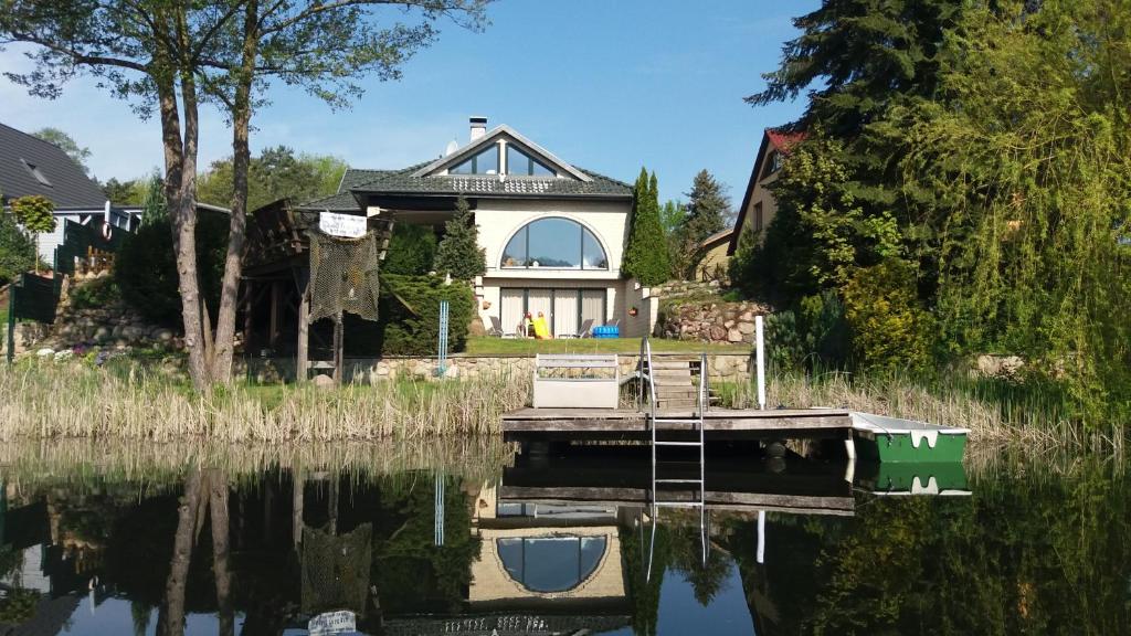 una casa sentada sobre un cuerpo de agua en KAMA Ferienhäuser Haus Kathrin, en Wendisch Rietz