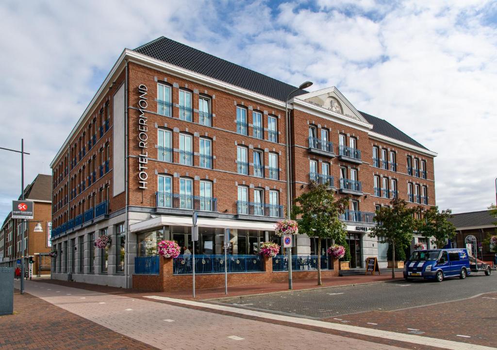 a large brick building on a city street at Hotel Roermond in Roermond