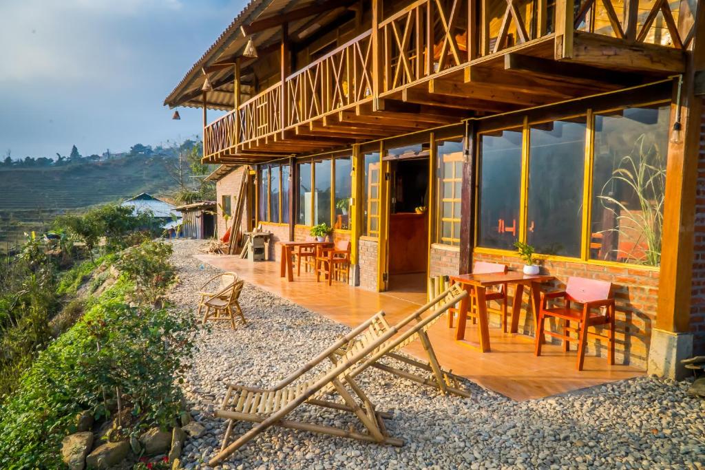 a house with a wooden deck with tables and chairs at Sapa's Soul in Sapa