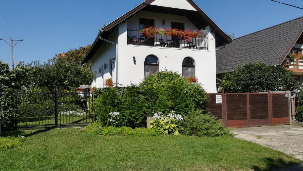 a white house with flower boxes on the windows at Orsolya apartman in Nyíregyháza