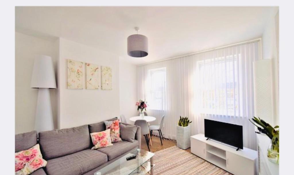 ein Wohnzimmer mit einem Sofa und einem Tisch in der Unterkunft Super location 1min from metro 10min from Camden in London