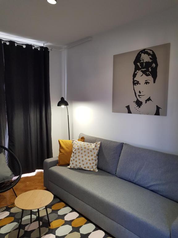 a living room with a blue couch and a table at WELCOME Apartment in Novi Sad