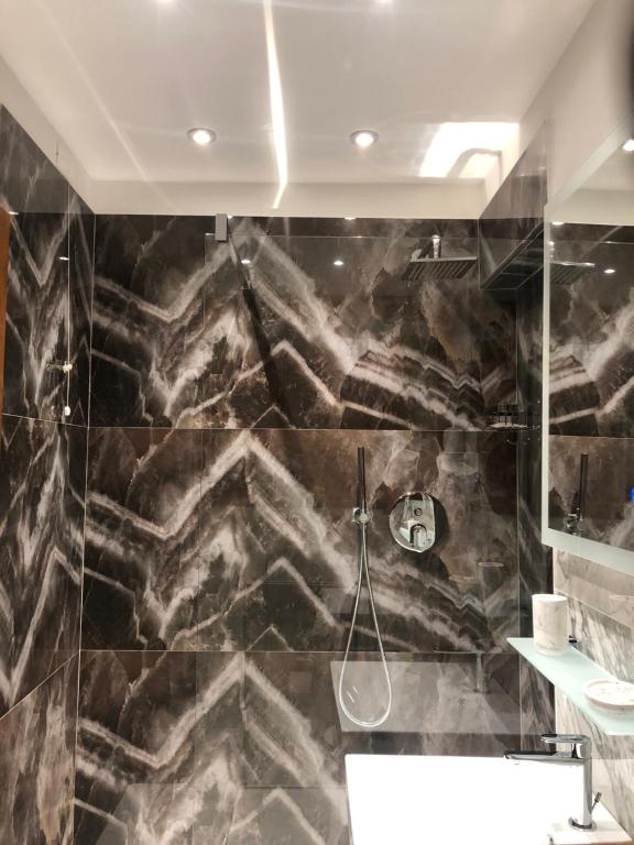 a bathroom with a black marble wall at Hotel Ariel Silva in Venice