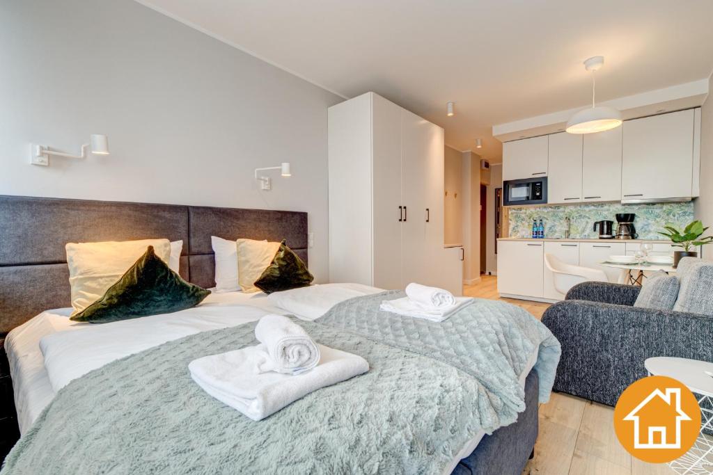 1 dormitorio con 1 cama grande y toallas. en Apartament z widokiem na port - visitopl, en Świnoujście