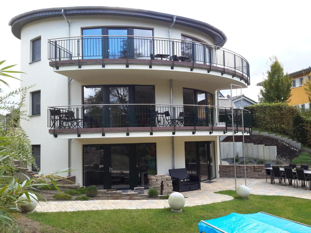 a white house with a balcony and a patio at KAMA Ferienhäuser Haus Karola in Wendisch Rietz