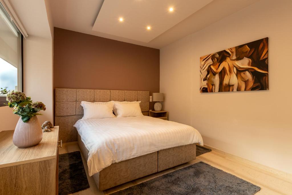 um quarto com uma cama e um quadro na parede em City Vibes, a KalamataStay Property em Kalamata