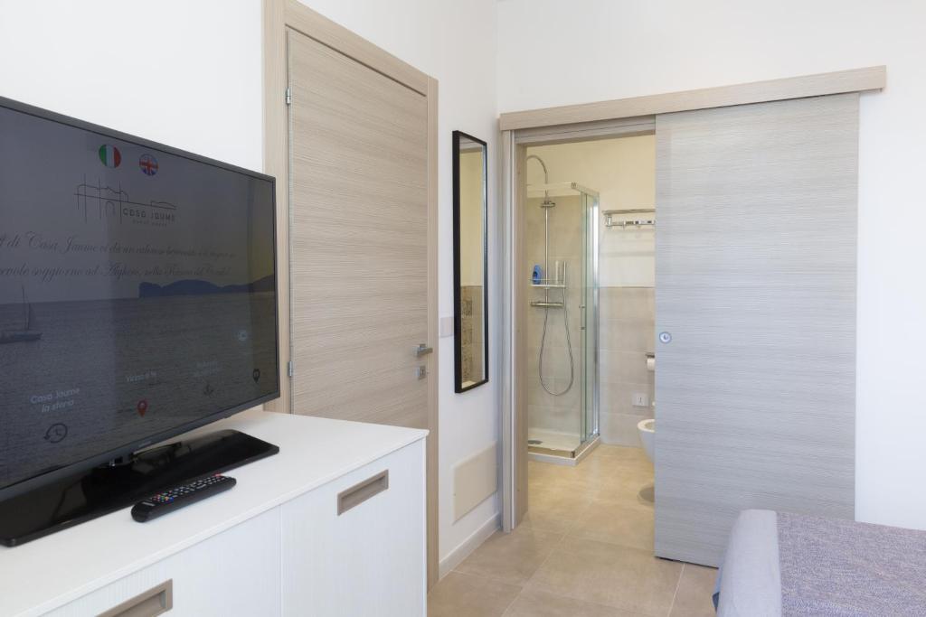 soggiorno con TV a schermo piatto e armadio bianco di Casa Jaume ad Alghero