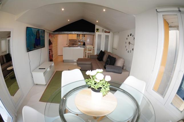 a living room with a glass table and white chairs at APARTAMENTOS URDAIBAI 5 in Bermeo