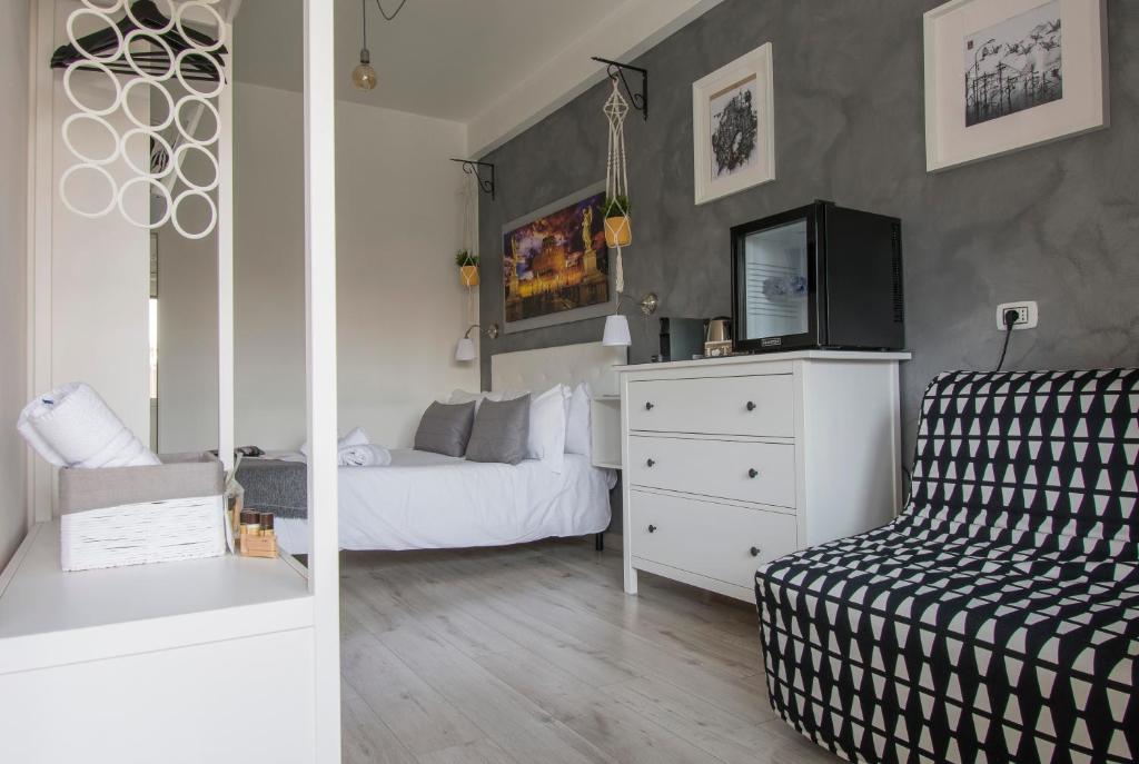 a bedroom with a bed and a tv on a dresser at Piccolo Hotel Boutique in Rome