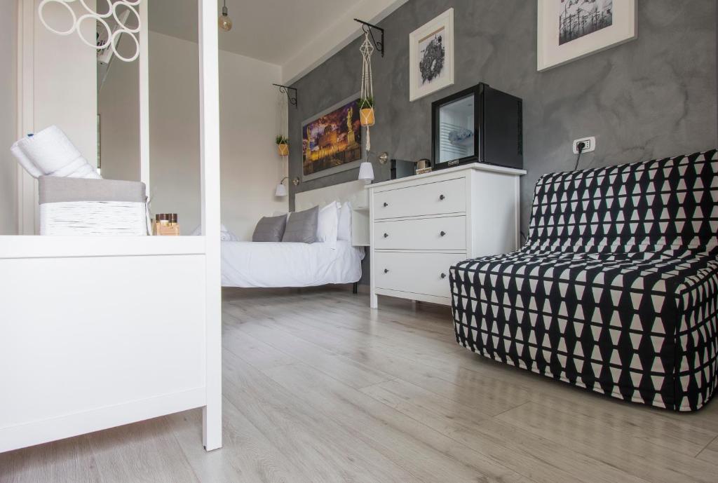 a bedroom with a couch and a dresser with a tv at Piccolo Hotel Boutique in Rome