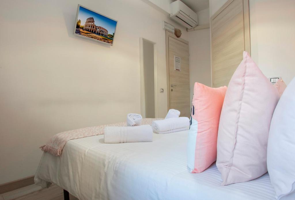 a bedroom with a bed with pink and white pillows at Piccolo Hotel Boutique in Rome