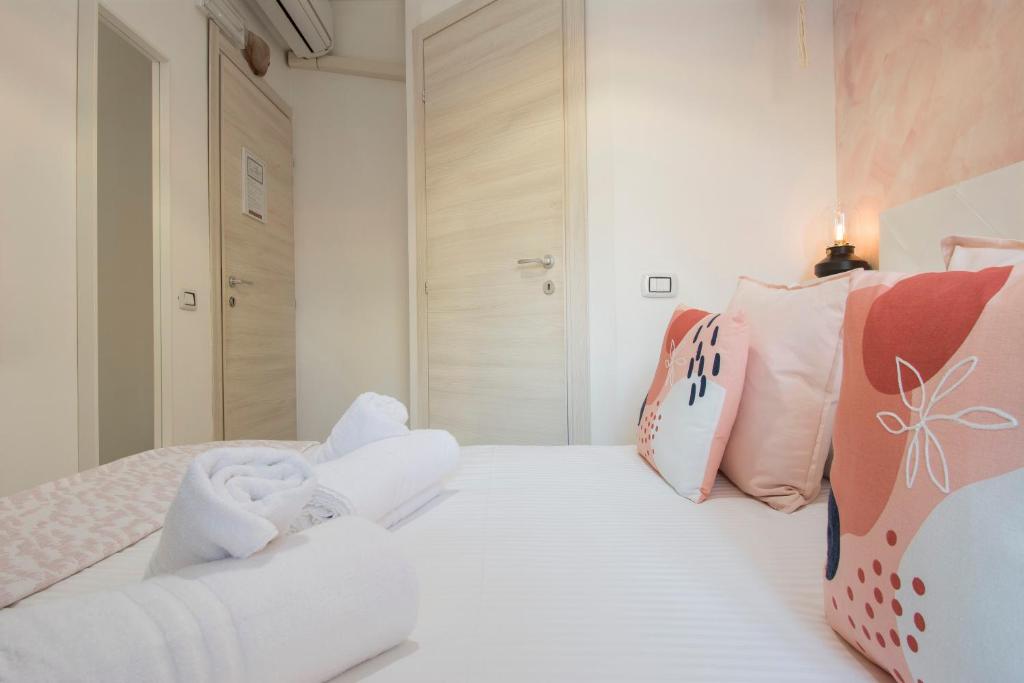 a bedroom with pink and white pillows on a bed at Piccolo Hotel Boutique in Rome