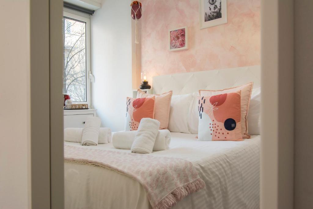 a bedroom with a white bed with pink walls at Piccolo Hotel Boutique in Rome