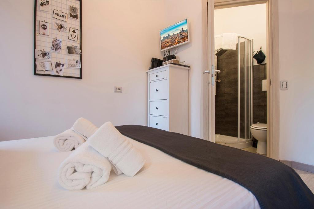 a bedroom with a white bed with towels on it at Piccolo Hotel Boutique in Rome