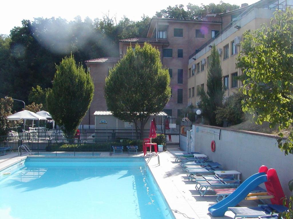 uma piscina com espreguiçadeiras e um escorrega em Hotel Tortorina em Urbino