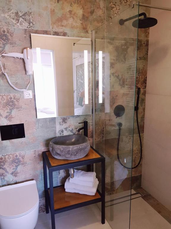 a bathroom with a shower and a sink and a toilet at Boutique Villa Revelin in Pag