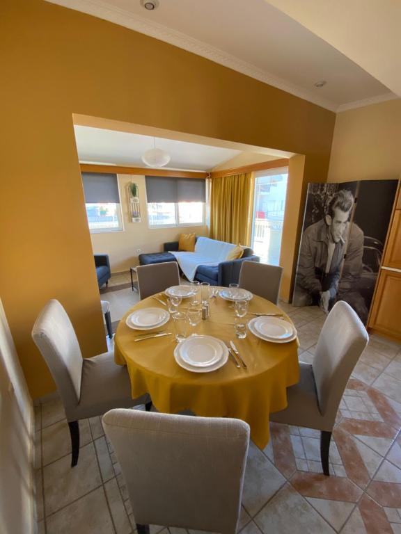 una sala da pranzo con tavolo e sedie gialli di Nancy's Apartment a Kalamáta