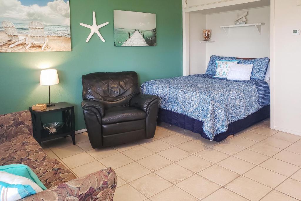 a bedroom with a bed and a chair next to a bed and a couch at Sand Dollar #5 in Corpus Christi