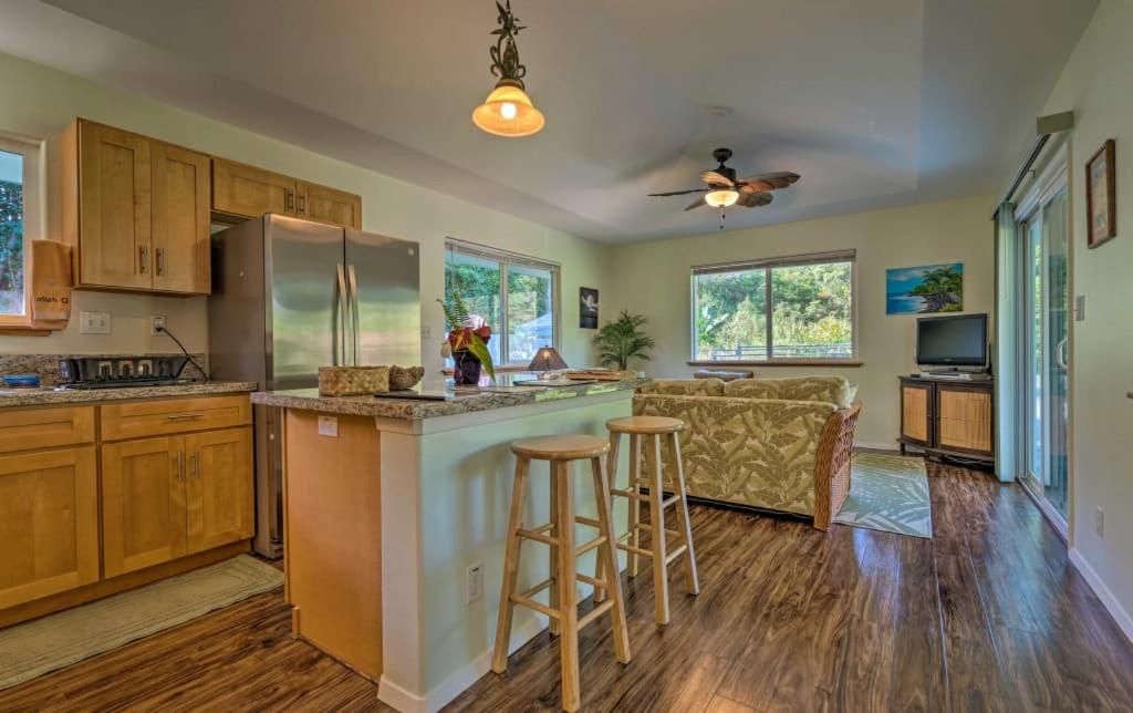 una cocina con armarios de madera y un bar con taburetes en Aloha Big Island Paradise, en Mountain View