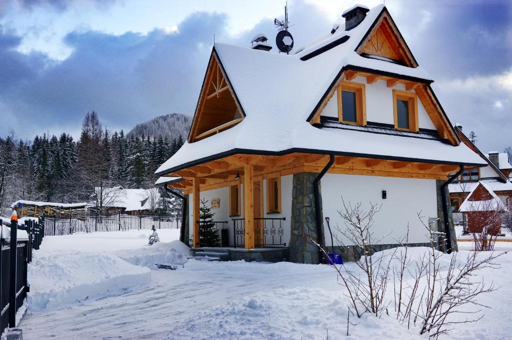 una casa cubierta de nieve en un patio en domek nad potokiem en Kościelisko