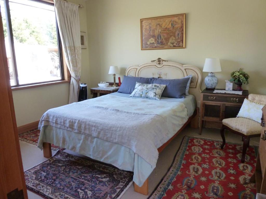 um quarto com uma cama grande e almofadas azuis em Redwood Valley B & B em Richmond