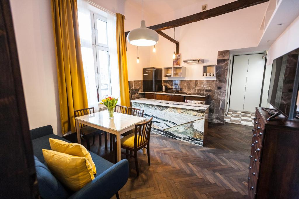 uma sala de estar com uma mesa e uma cozinha em Stylish Apartment in Krakow Old Town em Cracóvia