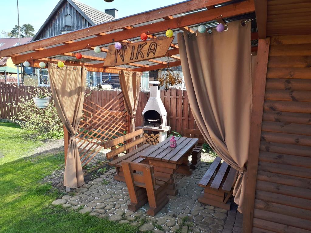 a wooden pergola with a picnic table and a grill at NIKA in Stegna