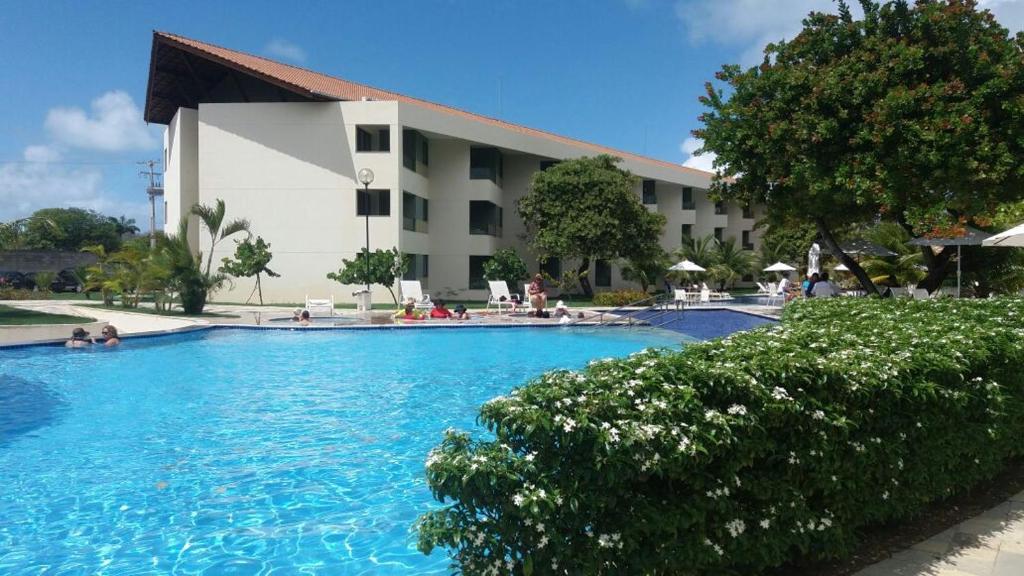 uma grande piscina em frente a um hotel em CARNEIROS BEACH RESORT- Flat de 2 quartos - condomínio à beira mar da Praia de Carneiros em Praia dos Carneiros