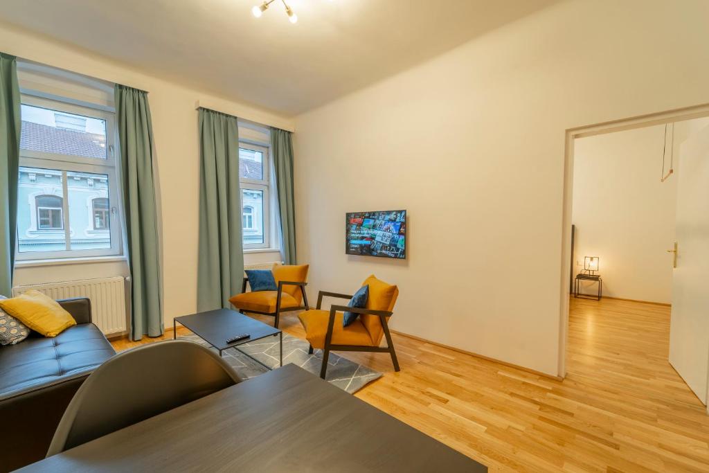 uma sala de estar com um sofá e cadeiras em Maximus I levestate em Viena