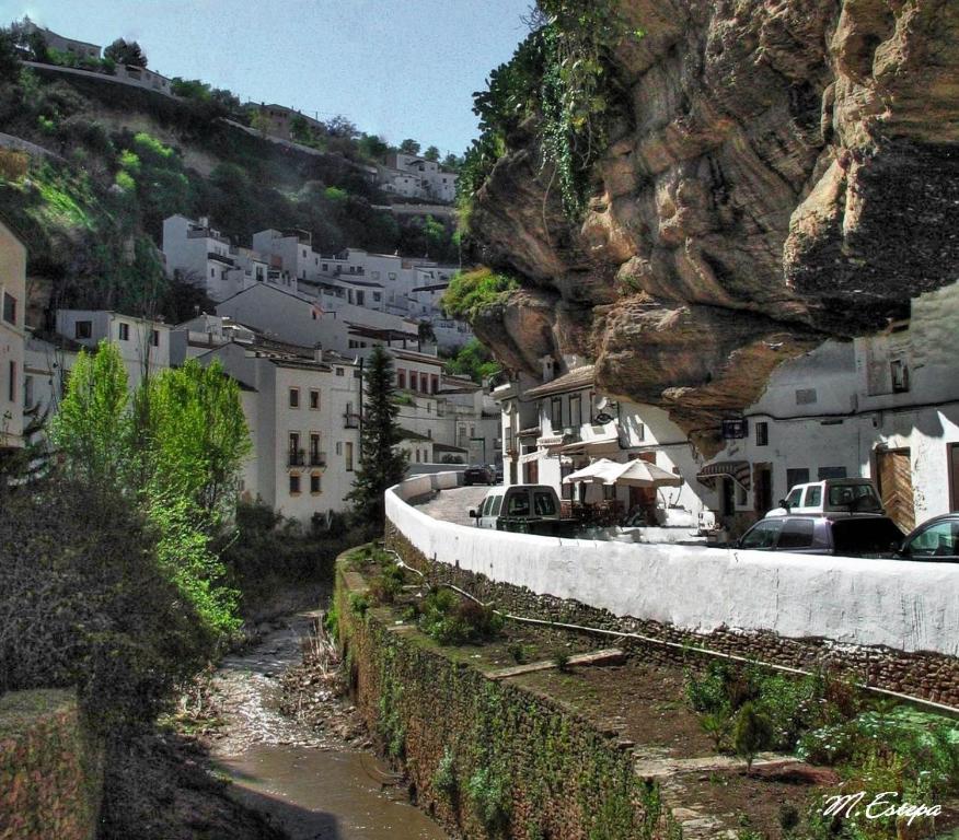 miasto na górze z samochodami na drodze w obiekcie Apartamento EntreCaminos w mieście Setenil