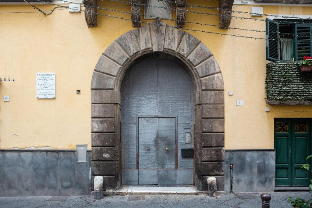 una gran puerta de madera en el lateral de un edificio en la dimora di Cornelia, en Sorrento