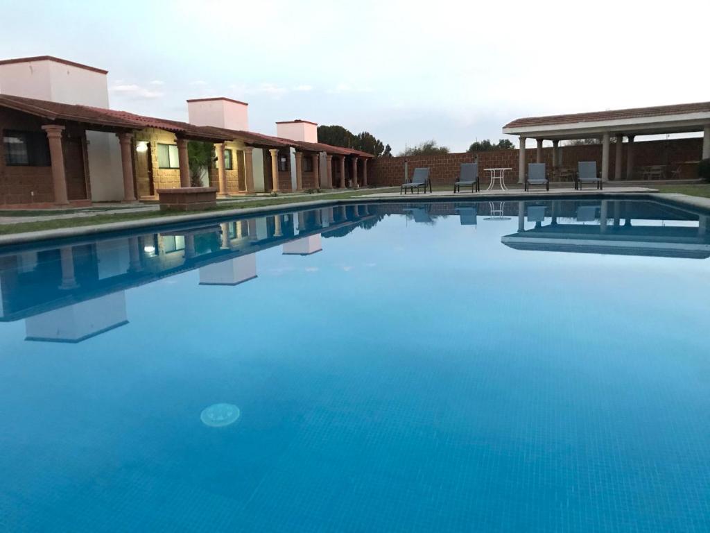 ein großer Pool mit blauem Wasser neben den Gebäuden in der Unterkunft Villas Amalur in Tequisquiapan