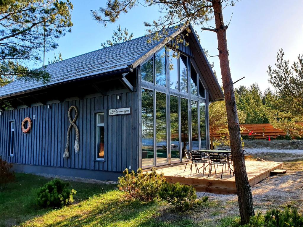 a blue building with a picnic table on a deck at Jūras Krasti Harmonija in Jūrmalciems