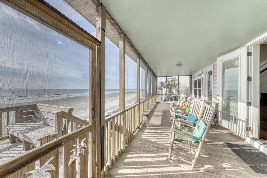 a porch with chairs and a view of the beach at Folly 'B' Golly in Folly Beach