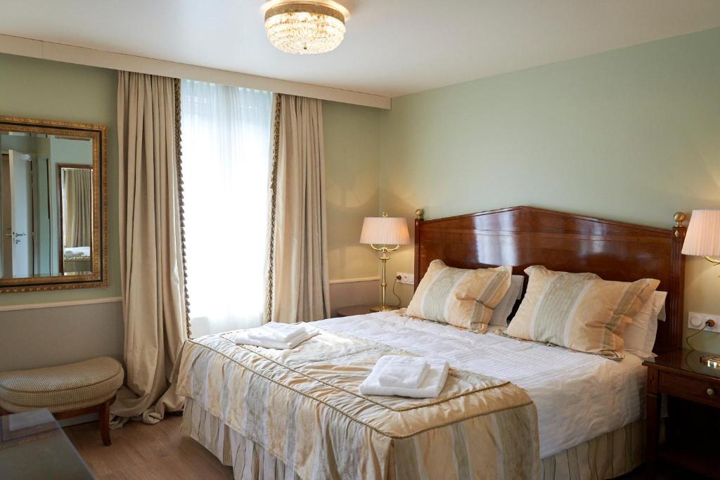 a bedroom with a large bed and a window at HOTEL Les Contes de Bruyeres in Servières-le-Château