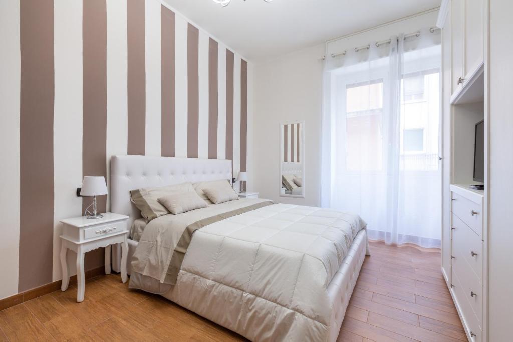 1 dormitorio con 1 cama con pared a rayas en Casa da Suite Gluck, en Milán