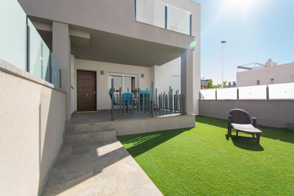 balkon z zieloną trawą i ławką w budynku w obiekcie 059 Luxury Bungalow - AC/WIFI w mieście Torrevieja