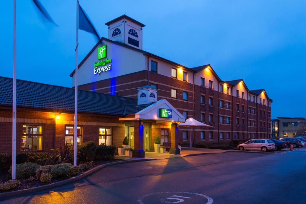 a large building with a clock tower on top of it at Holiday Inn Express Derby Pride Park by IHG in Derby