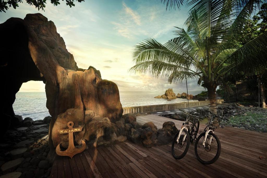 two bikes parked on a wooden boardwalk next to the ocean at Kajane Tulamben Bali in Tulamben