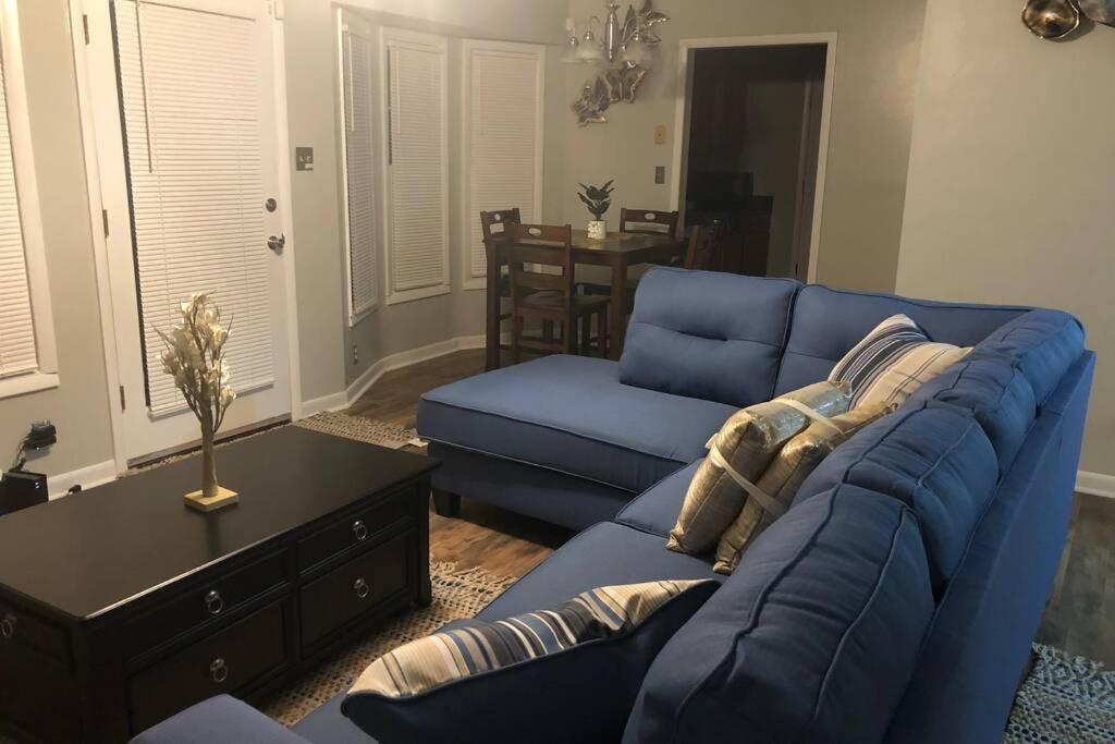 sala de estar con sofá azul y mesa en True-Mates Stay 5 minutes from Fort Bragg en Fayetteville