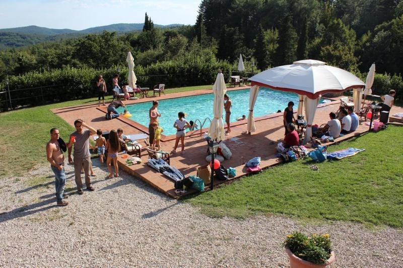 un grupo de personas sentadas alrededor de una piscina en Agriturismo La Quercia, en Boccheggiano