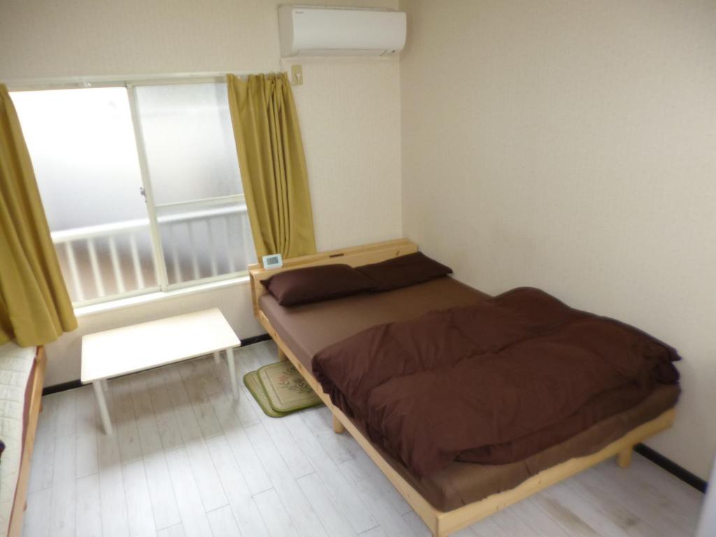 een kleine slaapkamer met een bed en een raam bij ザ ミッキー カールトン 井尻 202 in Shiobaru