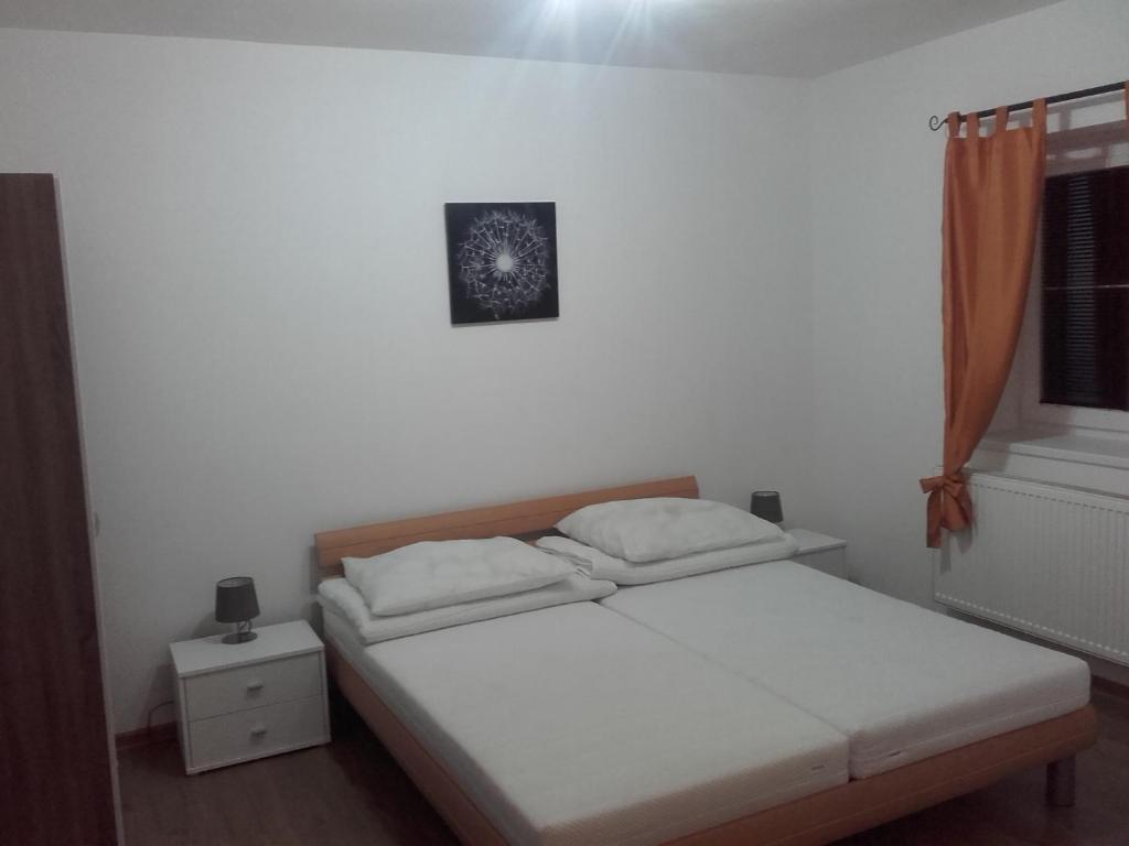a bed in a bedroom with a picture on the wall at A-Z Ubytovaní v soukromí Velké Losiny in Velké Losiny