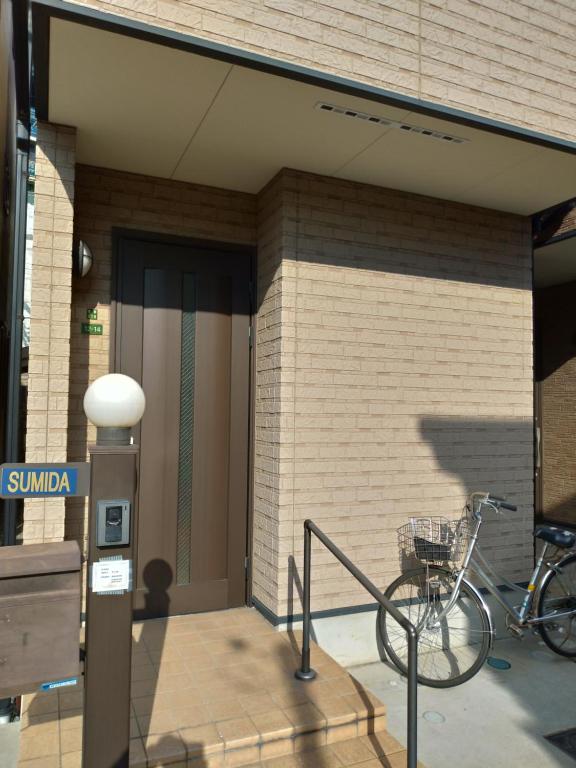 uma bicicleta estacionada ao lado de um edifício em SUMIDA em Osaka