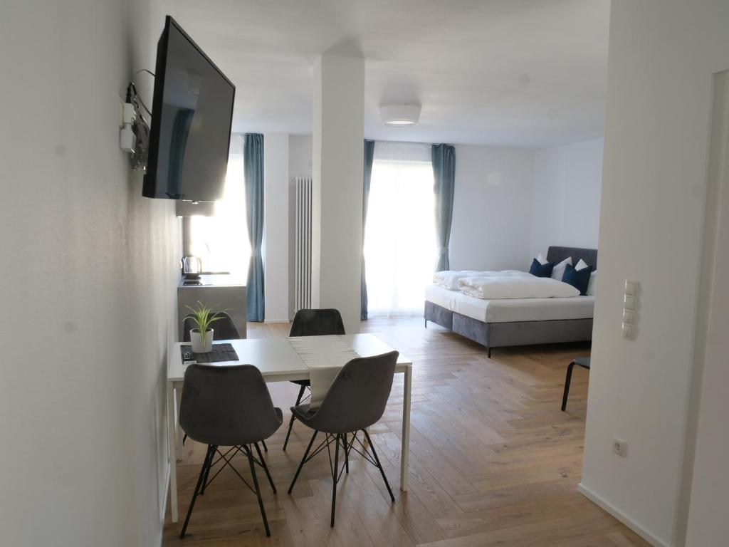 un soggiorno con tavolo, sedie e letto di Apartments Sabine G a Merano