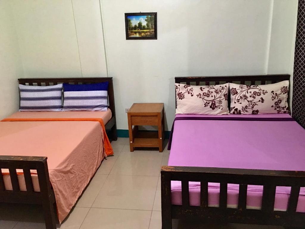 two beds sitting in a room with at JEMZ Tagaytay Budget Transient in Tagaytay