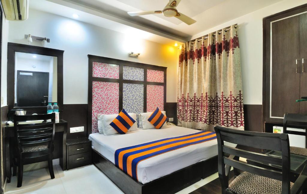 a bedroom with a bed and a desk and a television at THE BONLON INN-NEAR BLK HOSPITAL in New Delhi