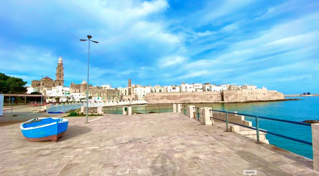 a pier with a city and the water at Cala Portavecchia in Monopoli